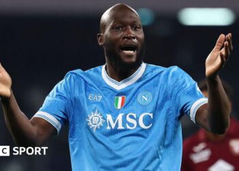 Romelu Lukaku in Napoli's light blue shirt, with raised arms held out in front of him