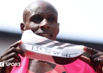Sabastian Sawe holds up the Adidas supershoe which he wore in breaking the marathon world record in London