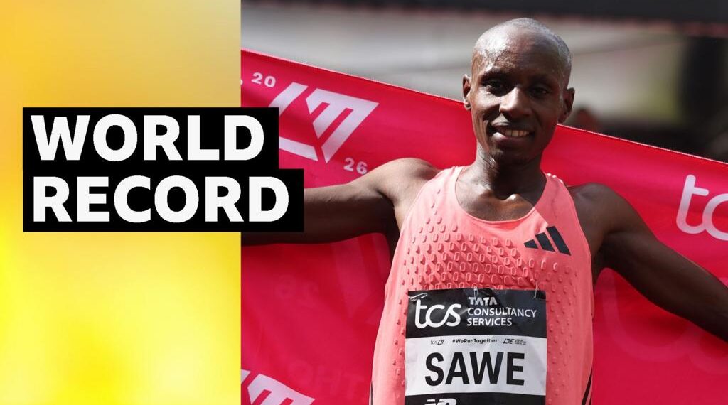 Sebastian Sawe holds up red flag behind his back after winning the 2026 London Marathon