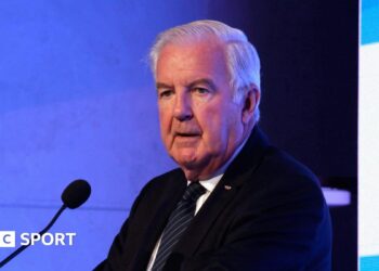 Sir Craig Reedie speaking at a podium in 2018