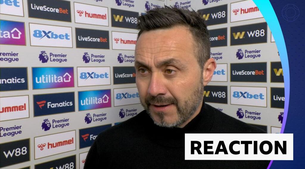 Roberto De Zerbi stands against advertising board in post match interview