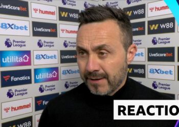 Roberto De Zerbi stands against advertising board in post match interview