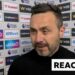 Roberto De Zerbi stands against advertising board in post match interview
