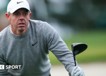 Rory McIlroy looks for his ball after hitting a tee shot
