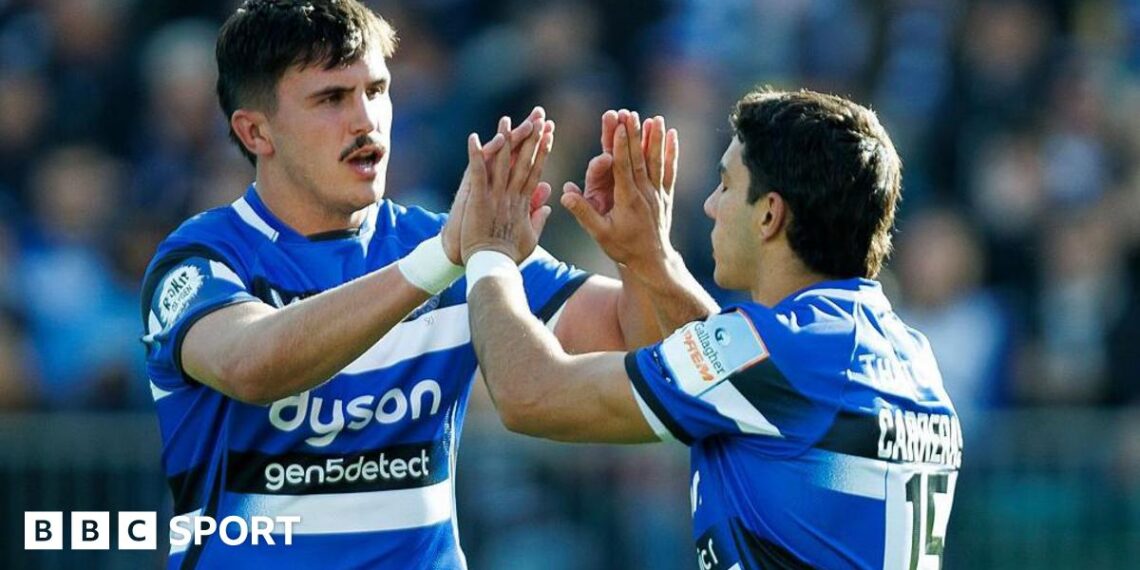 Ewan Richards (left) holds both hands up with palms wide to clap with Santiago Carreras (right)