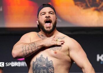 Louie Sutherland slaps his chest as he weighs in