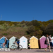 People make their way past beach huts on Bournemouth beach in Dorset.