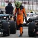 Lando Norris walks past a line of cars after the Japanese Grand Prix
