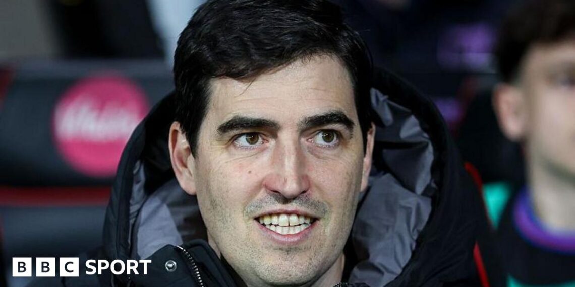 Bournemouth manager Andoni Iraola smiles as he watches a match