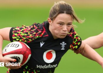Alisha Joyce with ball under right arm runs forward in Wales training