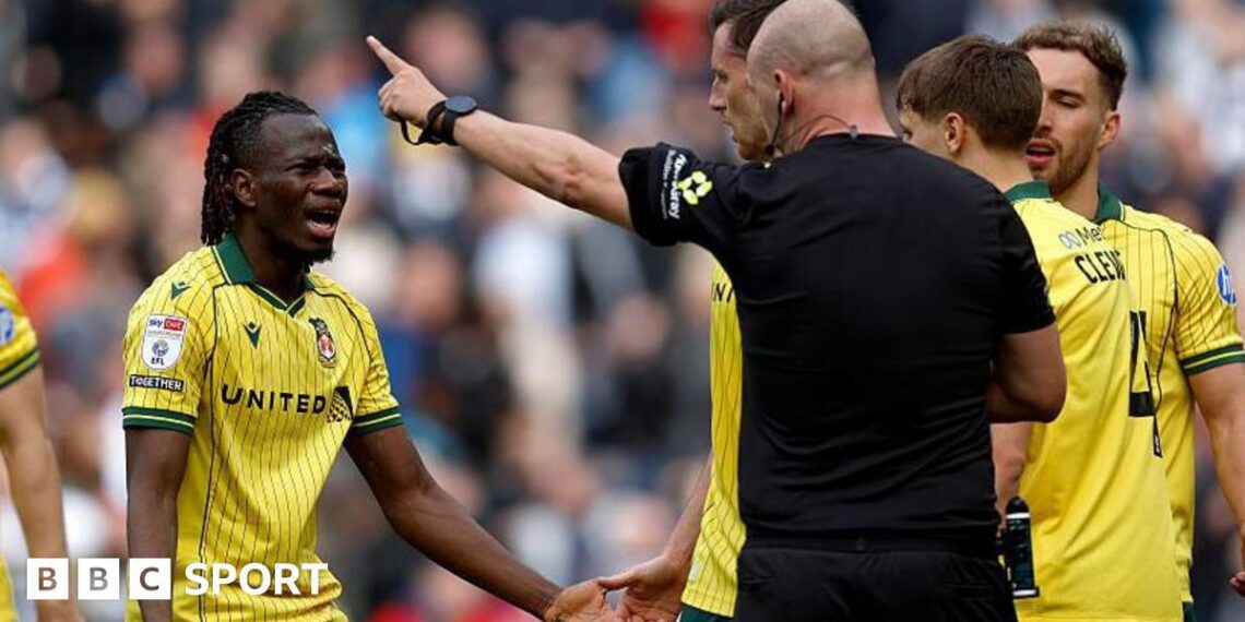 Wrexham's Issa Kabore (left) protests with referee Robert Madley