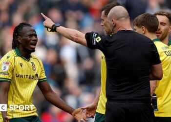 Wrexham's Issa Kabore (left) protests with referee Robert Madley