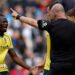 Wrexham's Issa Kabore (left) protests with referee Robert Madley