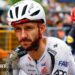 Adam Yates in a torn cycling kit and helmet, both predominantly white