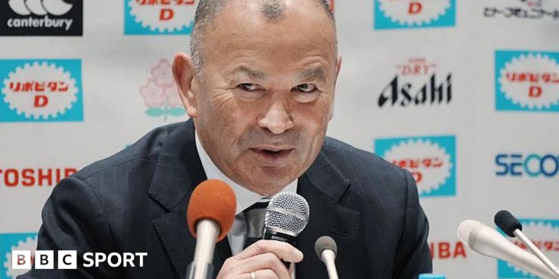 Eddie Jones speaks into a microphone