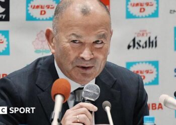 Eddie Jones speaks into a microphone