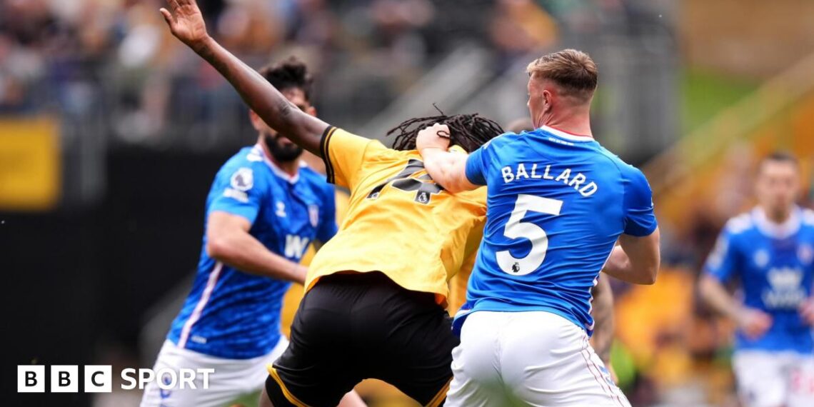 Referee Paul Tierney speaks with Lisandro Martinez of Manchester United after showing him a red card for pulling the hair of Dominic Calvert-Lewin of Leeds United