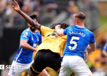 Referee Paul Tierney speaks with Lisandro Martinez of Manchester United after showing him a red card for pulling the hair of Dominic Calvert-Lewin of Leeds United