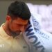 Novak Djokovic reacts during the Italian Open, raising a towel to his face while wearing a yellow tennis shirt