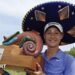 Nelly Korda celebrates winning the Riviera Maya Open in Mexico, wearing a traditional large Mexican hat and blue golf shirt, smiling, and holding a colourful trophy