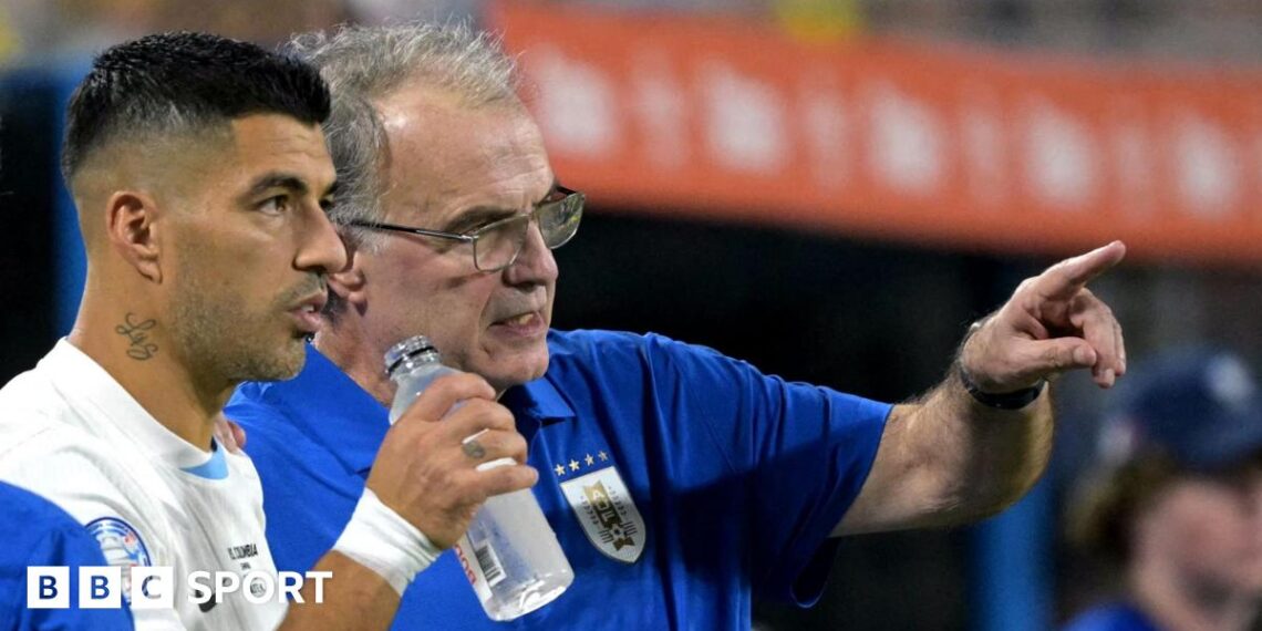 Marcelo Bielsa pointing while standing on the sidelines with Luis Suarez