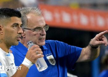 Marcelo Bielsa pointing while standing on the sidelines with Luis Suarez