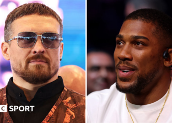 Oleksandr Usyk wearing sunglasses and and orange vest and Anthony Joshua wearing a white t-shirt