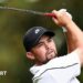 Alex Fitzpatrick watches his ball after playing an iron shot, with the club above his head