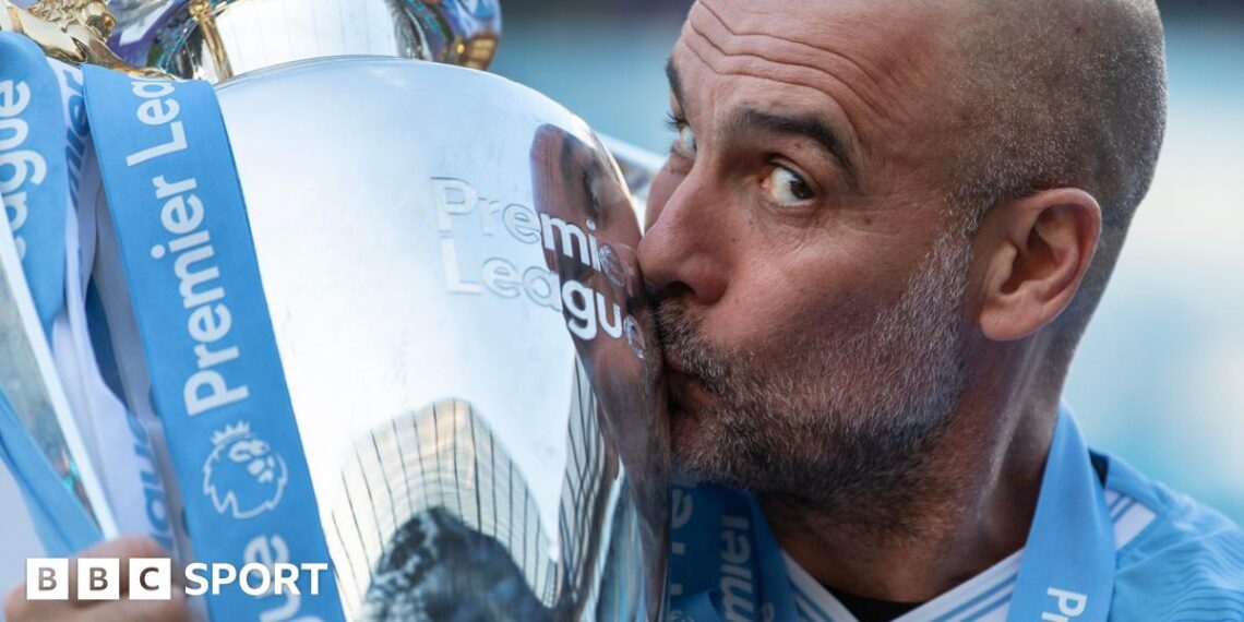 Pep Guardiola kisses the Premier League trophy