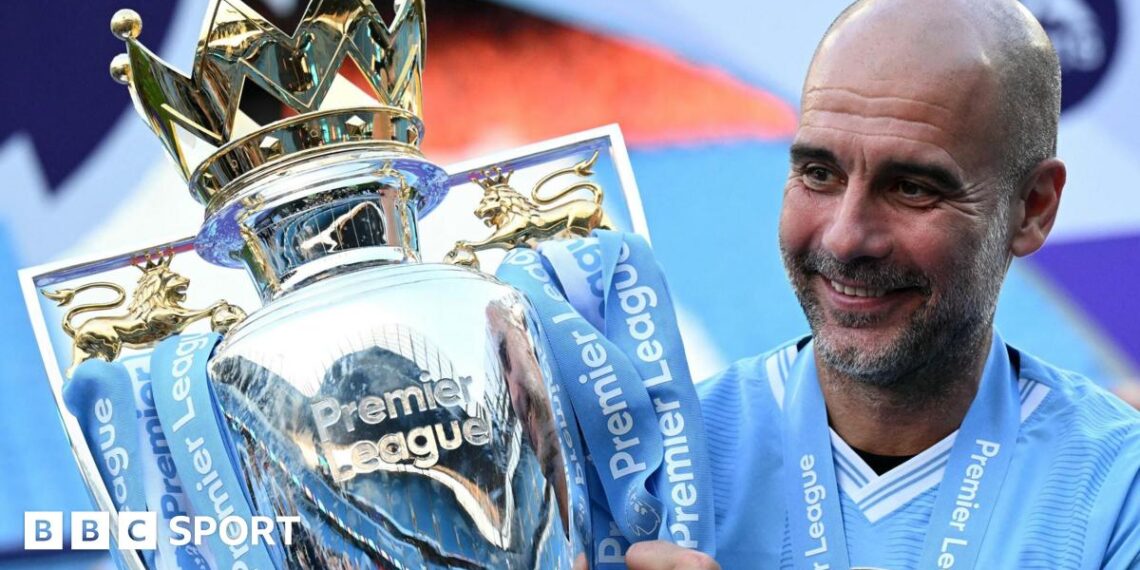 Pep Guardiola sitting down with trophies around him