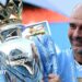 Pep Guardiola sitting down with trophies around him
