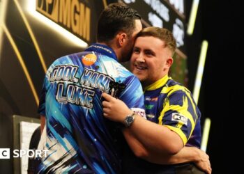 Luke Littler (right) embraces Luke Humphries after victory in the final on night thirteen of the BetMGM Premier League 2026 at P&J Live, Aberdeen.