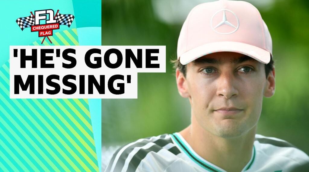 George Russell close up. He is wearing a pale pink cap with a Mercedes logo on it.