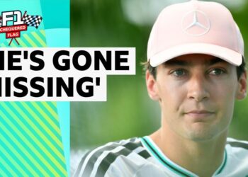George Russell close up. He is wearing a pale pink cap with a Mercedes logo on it.