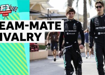 Kimi Antonelli and George Russell walking together dressed in Mercedes race suit
