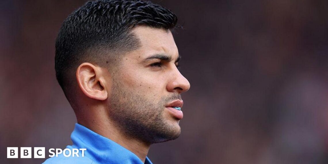 Cristian Romero looks on