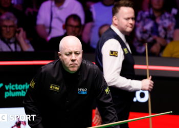 John Higgins eyes a shot
