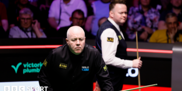 John Higgins eyes a shot