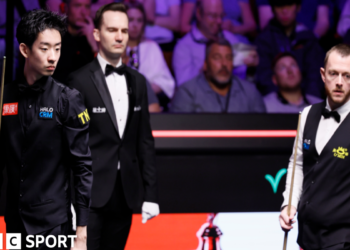 Wu Yize and Mark Allen assess a shot