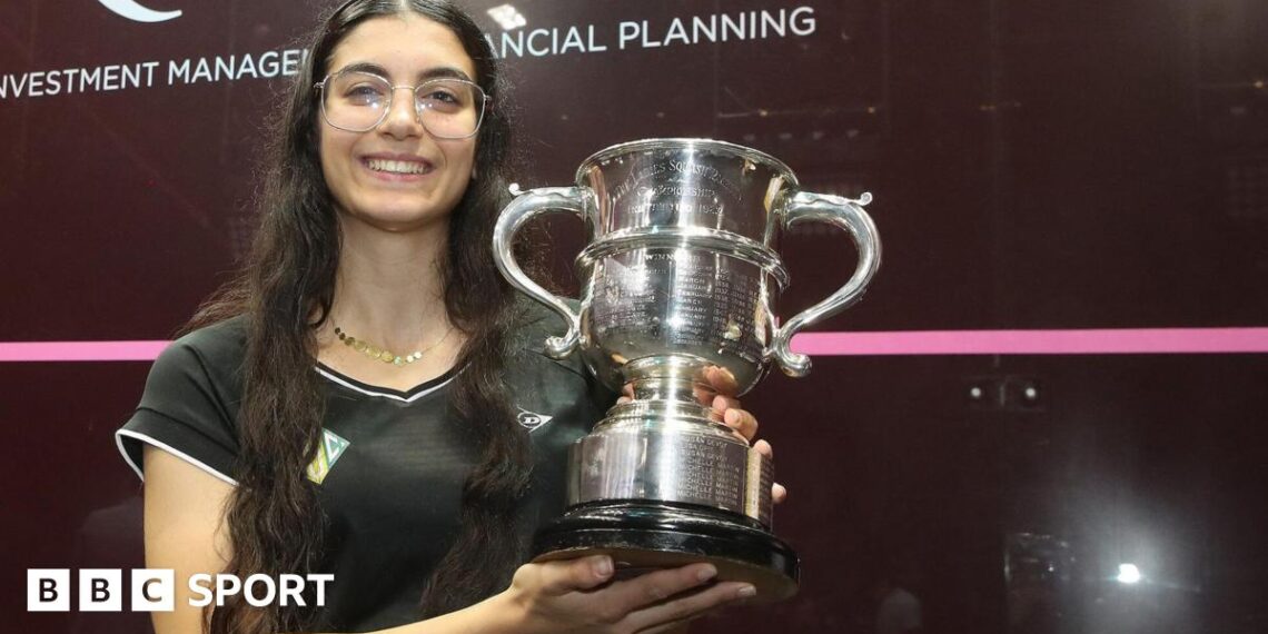 Amino Orfi holding her trophy and smiling