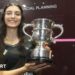 Amino Orfi holding her trophy and smiling