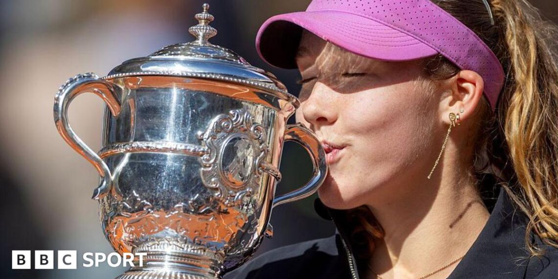 A close-up of Mirra Andreeva's jacket bearing the phrase 'I want to thank myself' while she holds the French Open winners' trophy