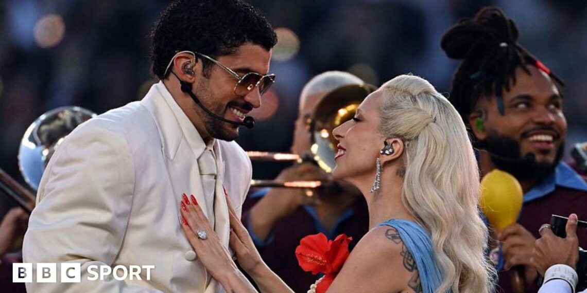 Bad Bunny and Lady Gaga smiling at each other as they perform the half-time show at Super Bowl 60