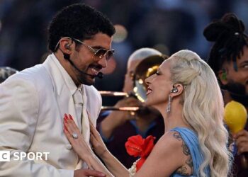 Bad Bunny and Lady Gaga smiling at each other as they perform the half-time show at Super Bowl 60