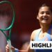 Emma Raducanu smiling and holding racket up