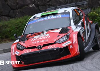 Elfyn Evans' red and white Toyota Yaris Rally1 car corners at Rally Japan