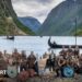 Norway players in Viking dress and with weapons and shields pose in front of a fjord with Viking boats