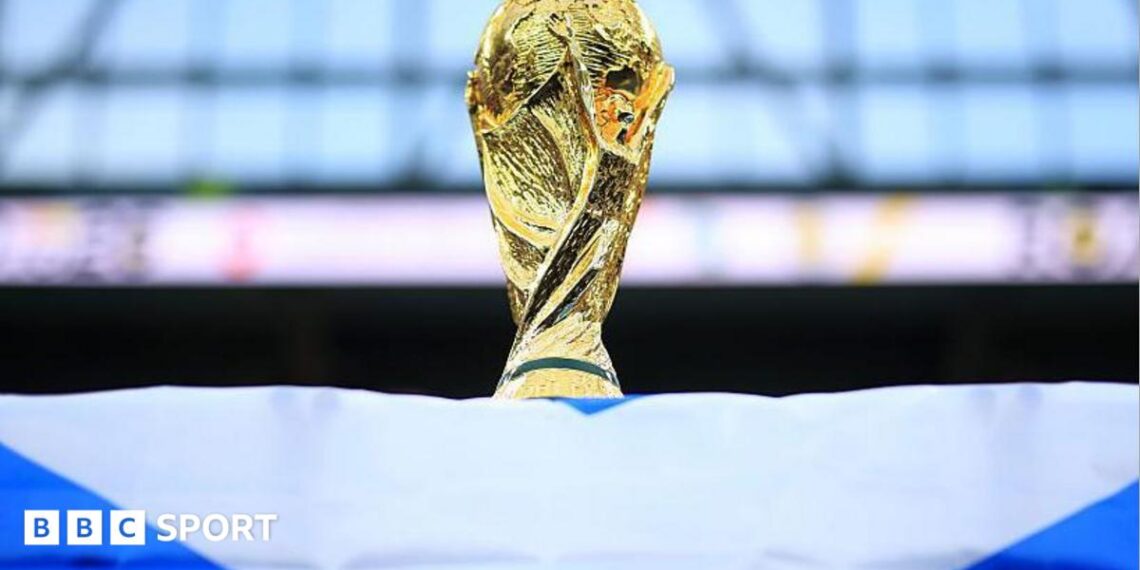 A World Cup trophy is perched on top of a Scotland flag.