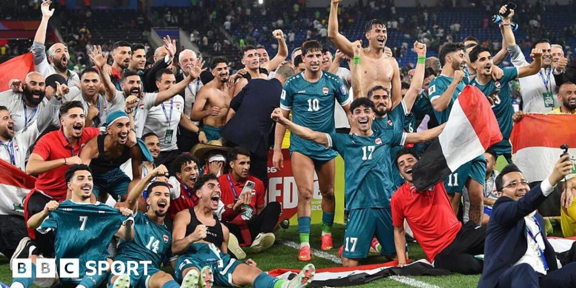 The Iraq squad celebrate on the pitch after sealing World Cup qualification