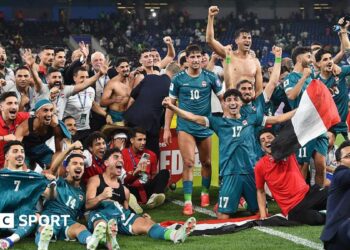 The Iraq squad celebrate on the pitch after sealing World Cup qualification